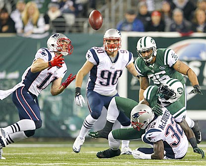 A fumble by Joe McKnight (bottom) lands in the hands of Julian Edelman, who returns it for a touchdown.  (Getty Images)