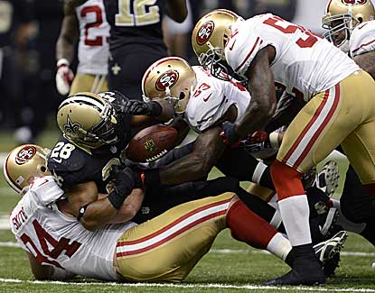 San Francisco's Justin Smith (94) and NaVorro Bowman (53) jar the ball loose from Mark Ingram. (AP)