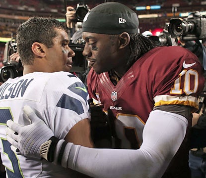 Fellow rookies Russell Wilson and RG3 embrace after the game. The Seahawks move on to face the No. 1 seed Falcons. (Getty Images)