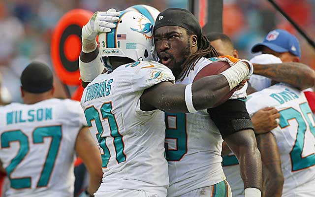 Dolphins LB Dannell Ellerbe hugs Michael Thomas after Thomas' clinching INT of Tom Brady. (USATSI)