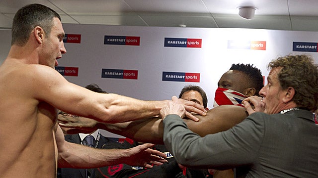 WBC heavyweight champion Vitali Klitschko (left) is slapped by Dereck Chisora during the official weigh-in. (AP)