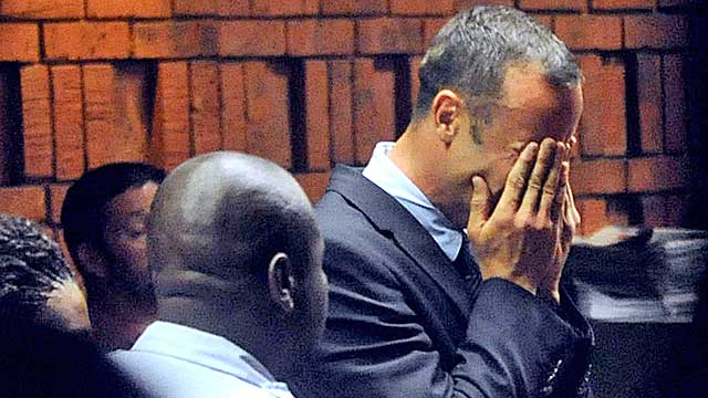 Pistorius hides his face in his hands in the court room during his hearing Friday. (Getty Images)