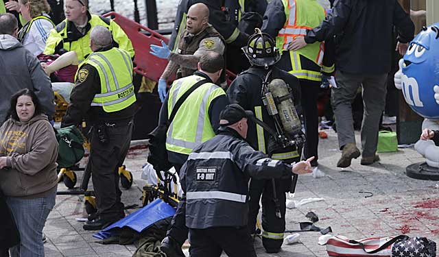 Police and fire rescue personnel move onto the scene after the explosions. (AP)