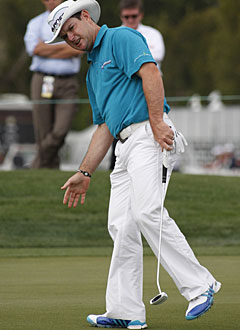 Rory Sabbatini uses a little body language to direct the ball in the cup on the ninth hole. (AP)