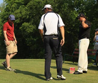 Padraig Harrington (middle) sorts out his tee-box confusion with Phil Mickelson and rules offical Ronan Flood. (Getty Images)