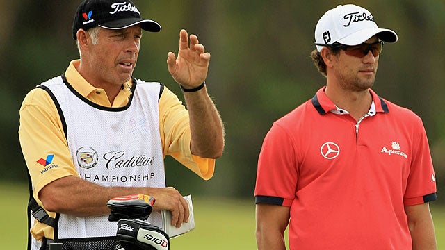 Adam Scott and caddie Steve Williams discuss the shot on the 10th hole. (Getty Images)