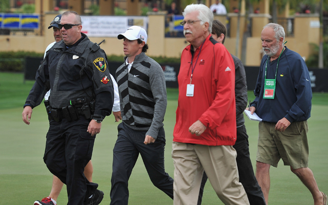 Rory McIlroy begin escorted off the course. (Getty Images)