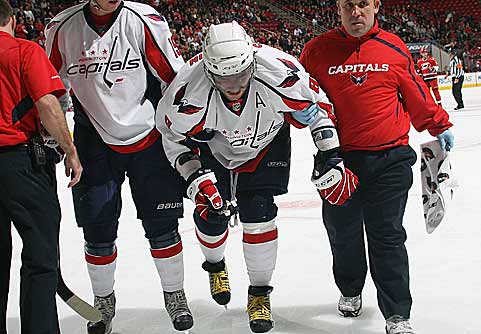 Ovechkin is helped off the ice after the collision.