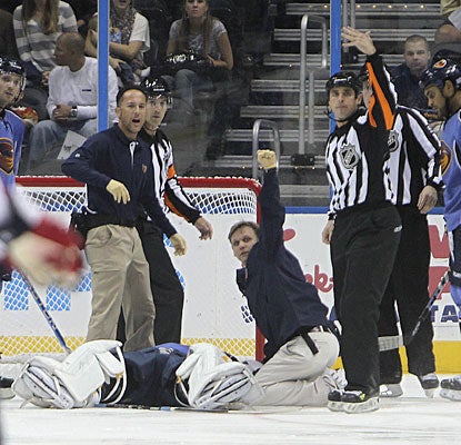 Game officials and medical personnel quickly signal for a stretcher to be brought to the ice for Ondrej Pavelec. (AP)