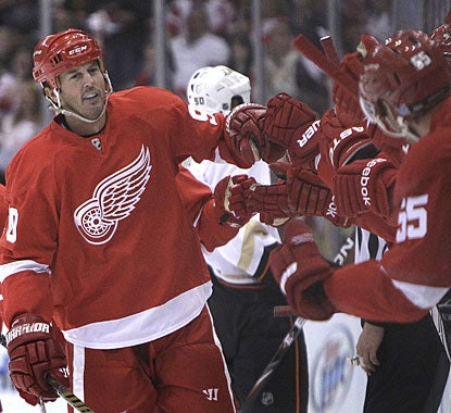 Welcome to the club Mike Modano! The Red Wings bench is happy with the veteran, who scores on his first shot on goal. (AP)