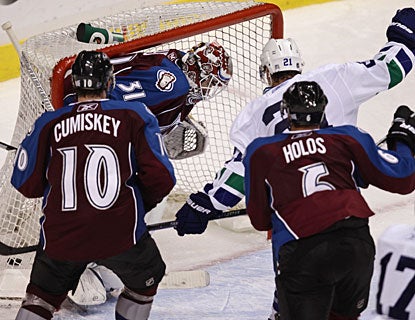 Mason Raymond (21) is fortunate to tap the puck on net and watch it trickle past Peter Budaj. (AP)