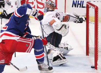 Artem Anisimov, left, scores past Oilers goalie Nikolai Khabibulin for one of the Rangers' four second-period goals. (AP)