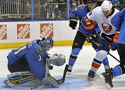 Thrashers goalie Ondrej Pavelec makes a save against Islanders center Zenon Konopka (28) en route to a 28-save win. (AP)