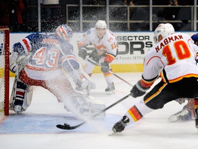 The Rangers' Martin Biron -- 31 saves -- gets iced by the Flames' Niklas Hagman. (Getty Images)