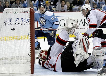 Sidney Crosby (rear) watches as his shot eludes Devils goalie Johan Hedberg and goes into the net.  (AP)