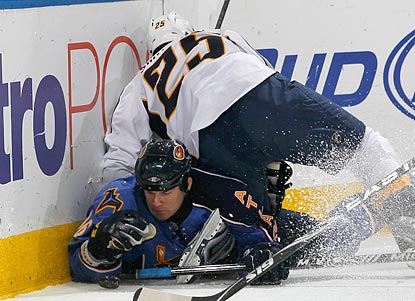 Atlanta's Eric Boulton falls to the ice under Nashville's Jerred Smithson during a hard-fought interconference battle.  (Getty Images)
