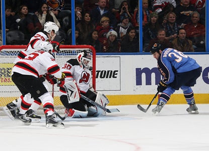 Eric Boulton flips the puck over Devils goalie Martin Brodeur's shoulder for one of his three goals. (Getty Images)