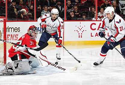 Mathieu Perreault (85), who nets two goals in the contest, and Brooks Laich (21) look for a rebound in front of Brian Elliott. (Getty Images)