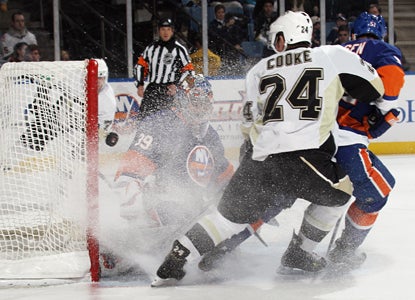 Matt Cooke (24) misses a deflection as Rick DiPietro of the Islanders reaches out to make a save. (Getty Images)