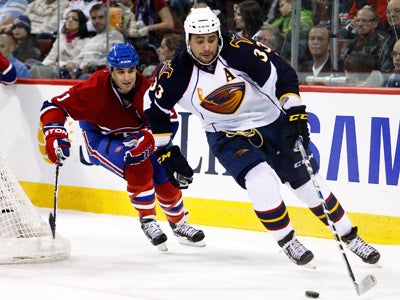 Scott Gomez skates with desperation while trying to keep up with the Thrashers' OT hero, Dustin Byfuglien. (Getty Images)