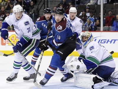 Roberto Luongo maintains solid position while opposing traffic tries to put one past him. (AP)