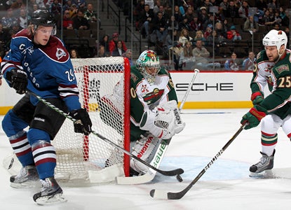 Ryan Stoa (29) tries to tip the puck past Wild goalie Jose Theodore but Theodore ends up the winner with 38 saves. (Getty Images)