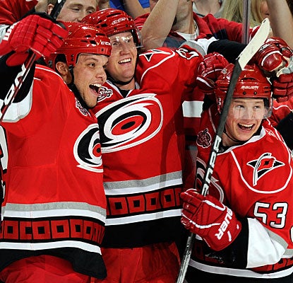 Joni Pitkanen (left) celebrates his winner with Derek Joslin and Jeff Skinner (53), who earlier nets his 25th goal. (Getty Images)