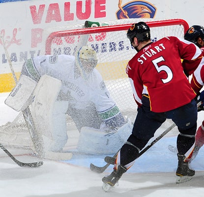 Roberto Luongo gets a face full of snow but makes the stop on Mark Stuart and goes on to post a 30-save shutout. (Getty Images)
