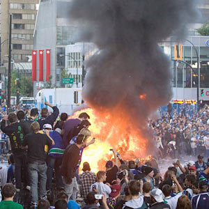 Fans in Vancouver set a few parked cars on fire after also tipping cars over. (AP)