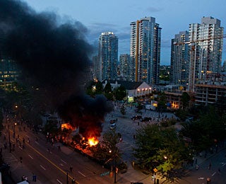 Police cars are set on fire, windows smashed and much more destruction on the streets of Vancouver. (AP)
