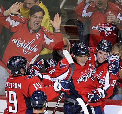 Mike Green (right) celebrates his overtime goal with Alexander Ovechkin and Nicklas Backstrom as fans also enjoy it. (AP)