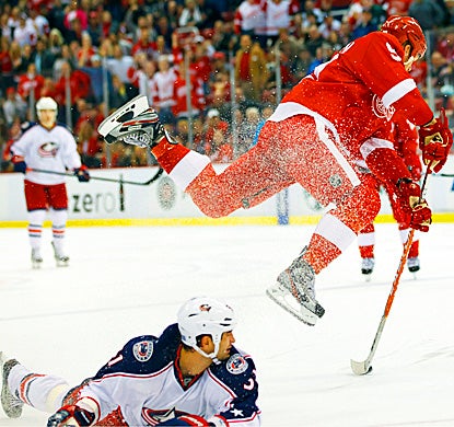 Johan Franzen leaps to shoot at an open net, scoring two power-play goals and adding an assist. (AP)