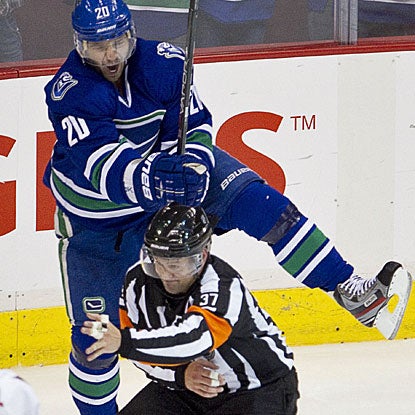 Christopher Higgins, celebrating behind the referee, is one of three Vancouver players to score two goals apiece. (AP)
