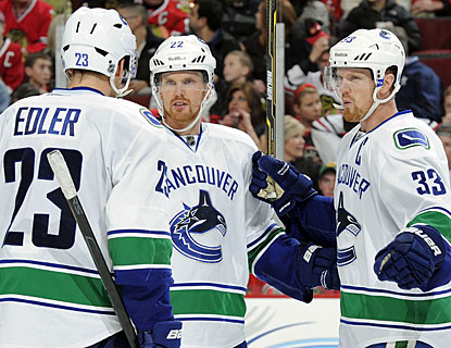 Henrik Sedin (33), who has one goal and threee assists, celebrates with twin brother Daniel and Alexander Edler. (Getty Images)