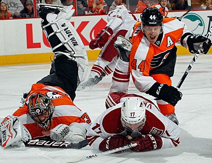 Former Coyotes goalie Ilya Bryzgalov is run over by Radim Vrbata as Kimmo Timonen also crashes down. (Getty Images)