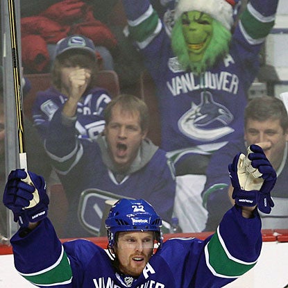 The Grinch is a Canucks fan? Daniel Sedin and fans enjoy the first of his three goals in the game. (AP)