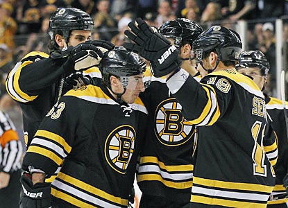 Teammates congratulate Brad Marchand (63), who scores twice in the shutout win against Los Angeles. (AP)
