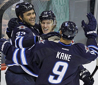 Bryan Little (center) celebrates his go-ahead power-play goal with Dustin Byfuglien and Evander Kane. (AP)