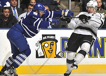  Dustin Brown (right) gets checked by Toronto's Carl Gunnarsson but would score the winner for L.A. in the shootout. (Getty Images)