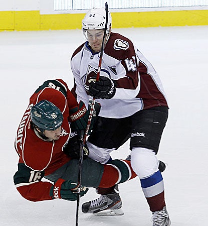 Colorado center Brad Malone (right) checks Minnesota's right wing Brad Staubitz off the puck during the Avs' win. (AP)