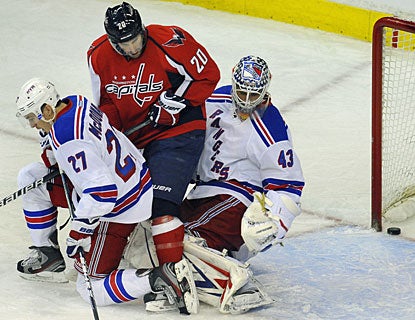 Troy Brouwer is sandwiched between the Rangers goalie and Ryan McDonagh, but is able to redirect the puck in the net. (AP)