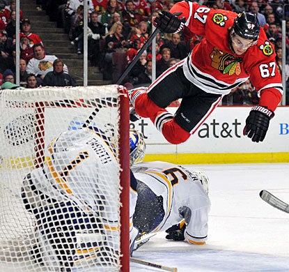 Blackhawks winger Michael Frolik goes airborne to avoid Sabres goalie Jhonas Enroth and defenseman Mike Weber. (US Presswire)