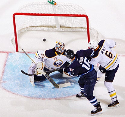 Andrew Ladd (16) wins the battle against Mike Weber in front of the crease to score the first goal for Winnipeg. (Getty Images)