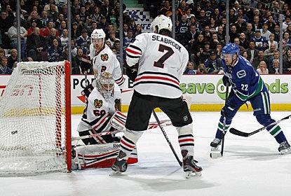 Daniel Sedin (22) scores the winner past Corey Crawford after his brother Henrik finds him open in front. (Getty Images)