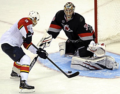  Florida's Stephen Weiss (left) drives into Carolina goalie Justin Peters for the winning goal during a shootout.  (AP)