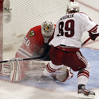 Mikkel Boedker forces the puck past goalie Corey Crawford in the fourth straight overtime in this series. (AP)