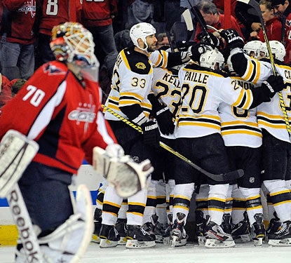 Braden Holtby skates away as the Bruins celebrate their second overtime victory of the series.  (Getty Images)