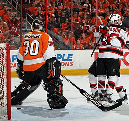 David Clarkson celebrates his fortunate goal with Zach Parise, while Ilya Bryzgalov is dejected after his blunder. (Getty Images)