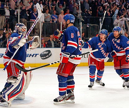 Henrik Lundqvist is pumped and cheered by his teammates after stopping 22 shots in the decisive game. (Getty Images)