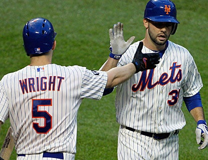 Dillon Gee is greeted by David Wright after scoring a run on a double by Mike Baxter. (AP)